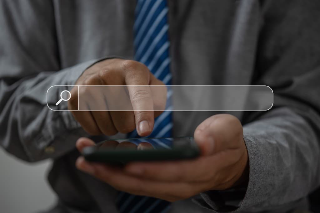 Business person using a smartphone with a search bar graphic